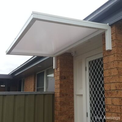 white Slimline 50 awning with fixed arms mounted between brick pillars over a unit front door